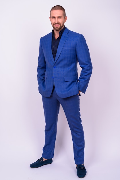 handsome bearded businessman in suit with shaved head looking cool on white