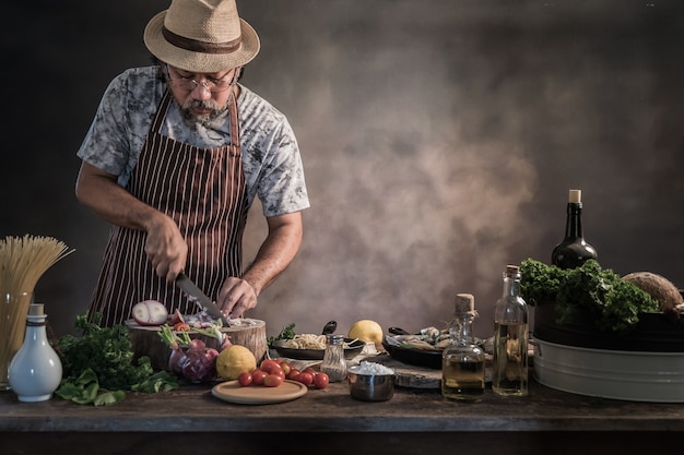 Handsome bearded cheef cook preparing spaghetti on a kitchen.