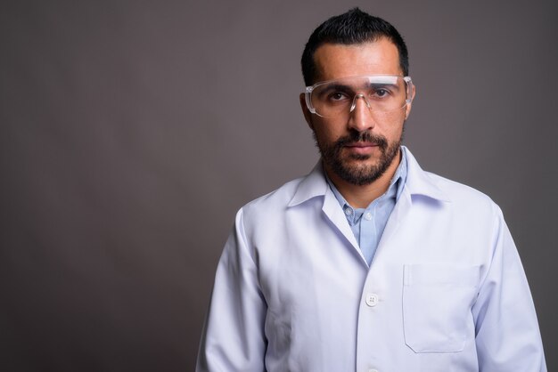 Handsome bearded doctor wearing protective glasses