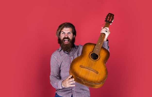 Photo handsome bearded guy with stylish hair playing acoustic guitar guitarist