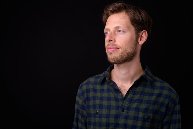 handsome bearded hipster man with brown hair against black space