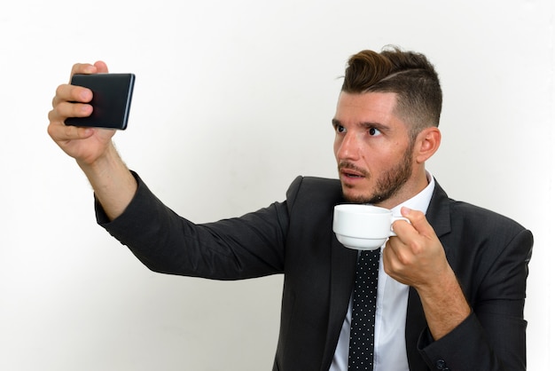 handsome bearded Hispanic businessman wearing suit on white