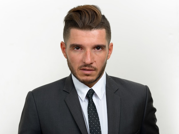 handsome bearded Hispanic businessman wearing suit on white