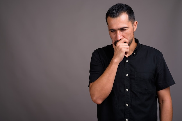 Handsome bearded man against gray wall