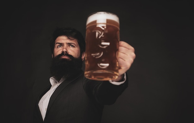 Handsome bearded man drinking beer portrait of handsome young man tasting a draft beer man holding m