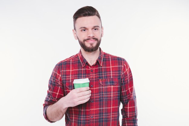 Handsome bearded man drinks coffee from paper cup Coffee to go Cafe concept Coffee shop Good morning Happy guy enjoy fresh hot tea Smiling barista offer you beverage