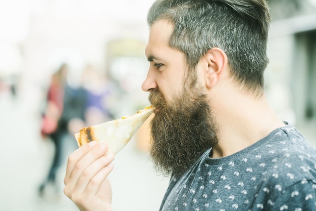 Handsome bearded man eating pizza