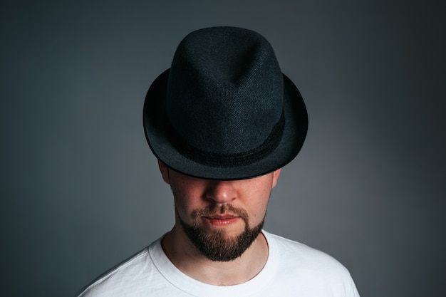 Foto uomo barbuto bello in cappello su un grigio