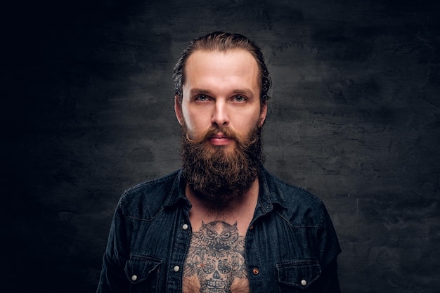 handsome bearded man is posing for photographer at dark photo studio.