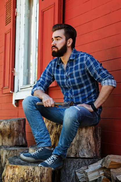 Handsome bearded man sitting on stump