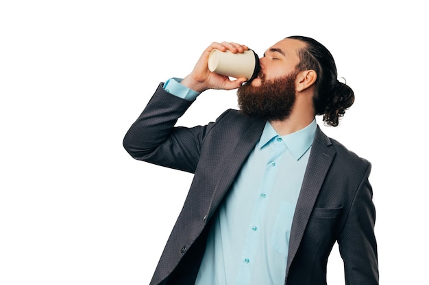 Handsome bearded man wearing shirt and jacket enjoys his to go coffee