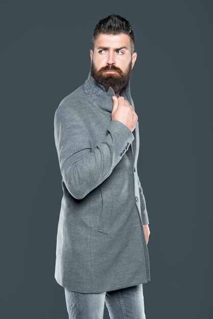 Handsome bearded mature guy wear jacket on grey background