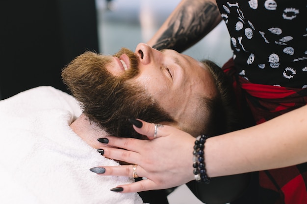 Handsome bearded and moustache man has shave in barbershop.