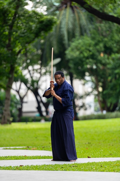 Foto uomo bello dell'artista marziale nero con il costume di arti marziali di kendo