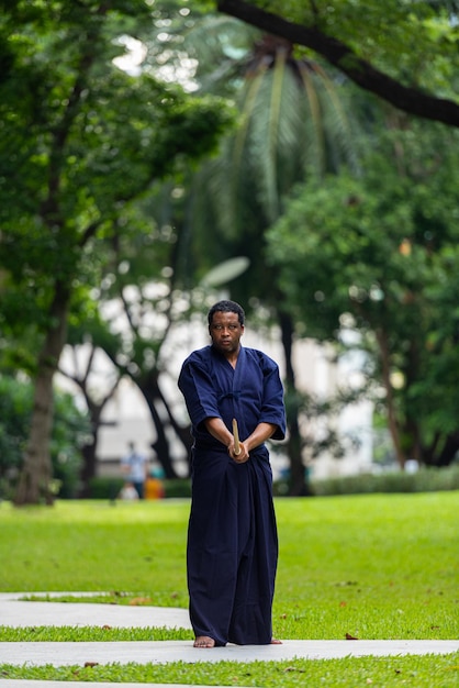 Foto uomo bello dell'artista marziale nero con il costume di arti marziali di kendo