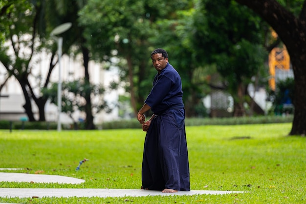 Uomo bello dell'artista marziale nero con il costume di arti marziali di kendo