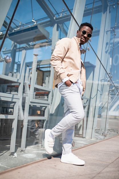 Handsome black young man in a jacket and white shirt on the street