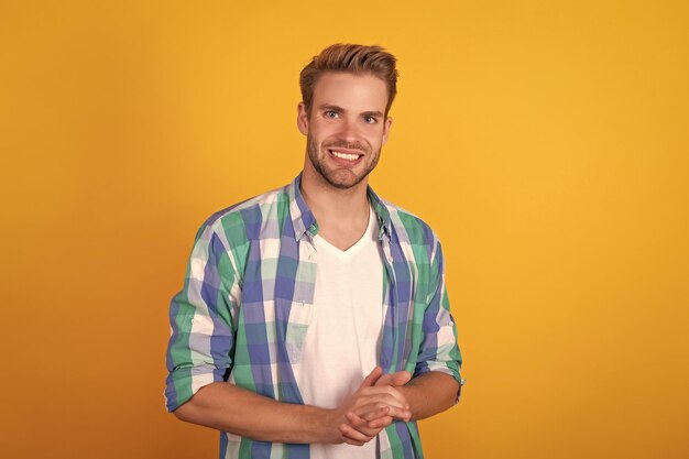 Foto handsome blanke jonge man portret gelukkig glimlachend in geruite shirt gele achtergrond man