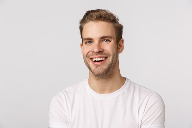 Ragazzo biondo bello con gli occhi azzurri e sorridere bianco della maglietta