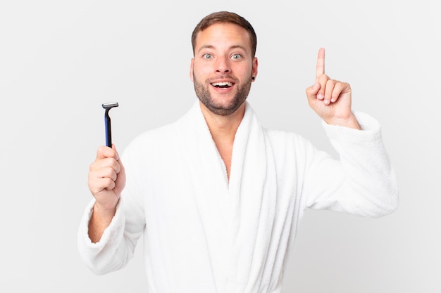 Handsome blonde man feeling like a happy and excited genius after realizing an idea. shaving concept