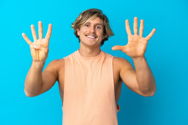 Handsome blonde man isolated on blue background counting nine with fingers