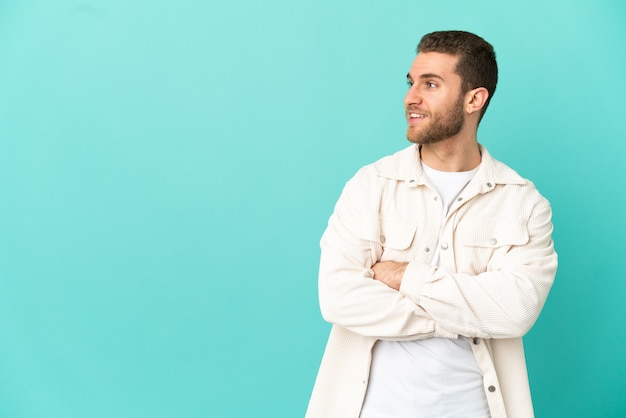 Handsome blonde man over isolated blue background happy and smiling