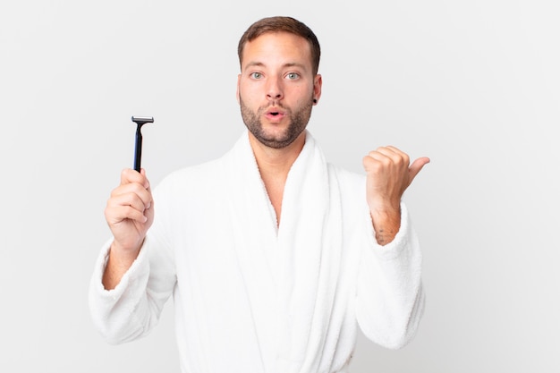 Handsome blonde man looking astonished in disbelief. shaving concept