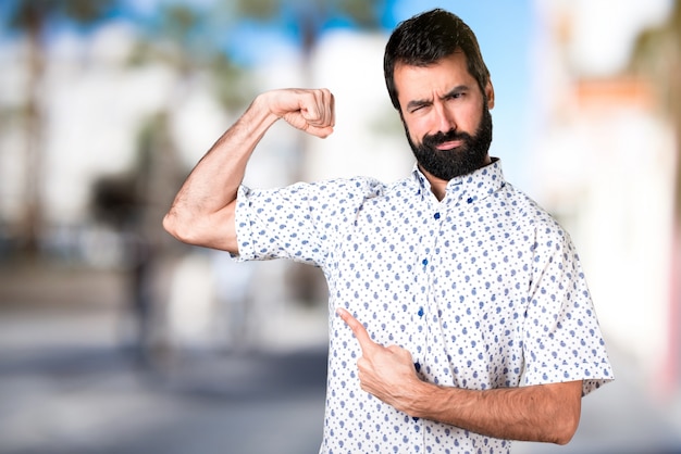 Handsome brunette man with beard making strong gesture