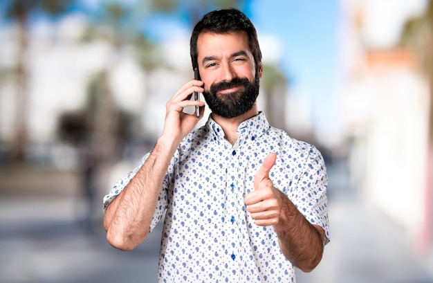 Handsome brunette man with beard talking to mobile