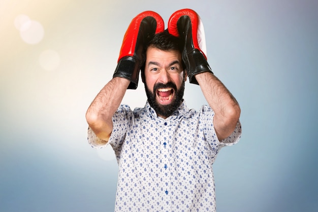 Handsome brunette man with beard with boxing gloves