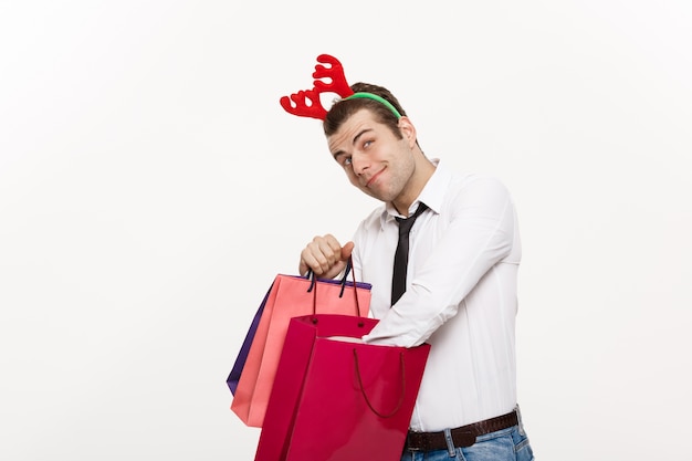 Handsome Business man celebrate merry christmas and happy new year wear reindeer hairband and holding Santa red big bag.