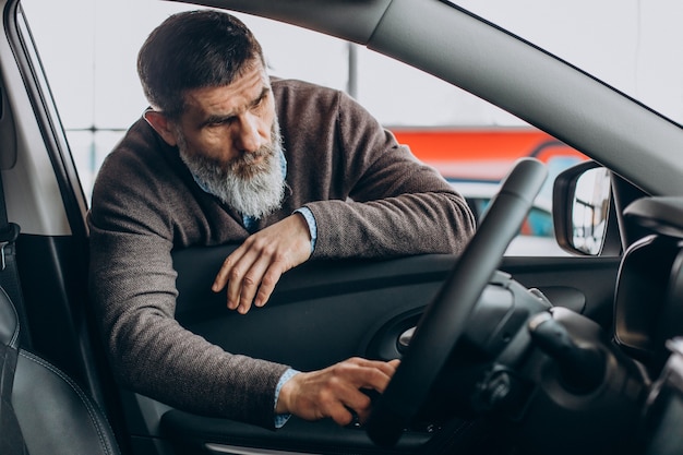 Handsome business man choosing a car in car showroom