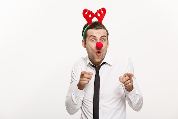 Handsome Business man wearing reindeer hairband making funny facial expression.