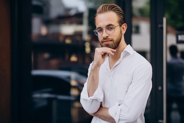 Handsome business man in white shirt walking at the street