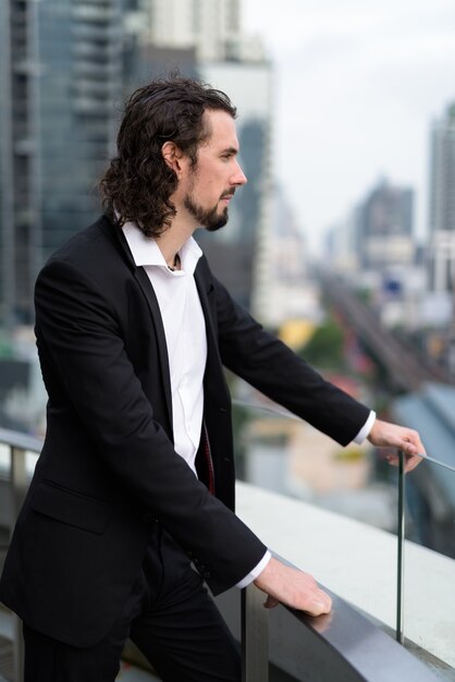 Handsome businessman against view of the city in Bangkok, Thailand