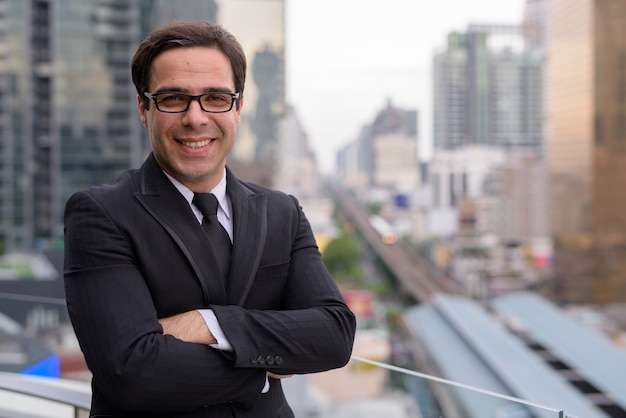 Handsome businessman against view of the city