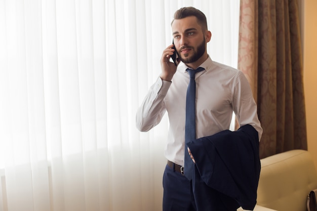 Handsome Businessman Calling from Hotel Room