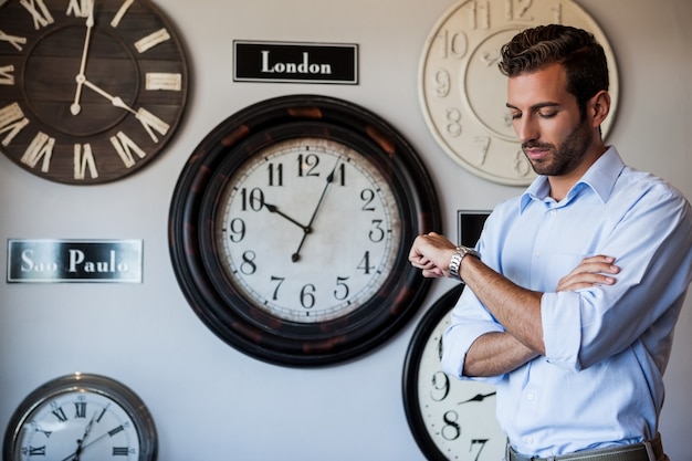 Uomo d'affari bello che controlla il tempo