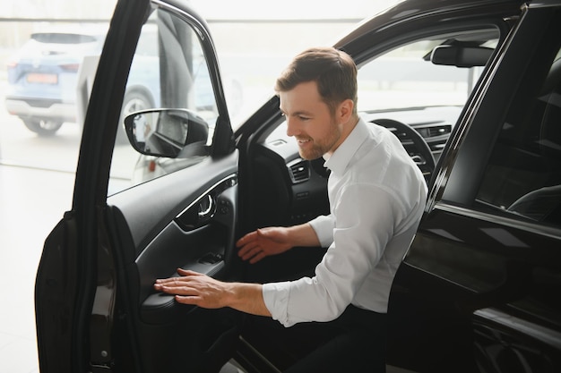 Handsome businessman driving car before buying