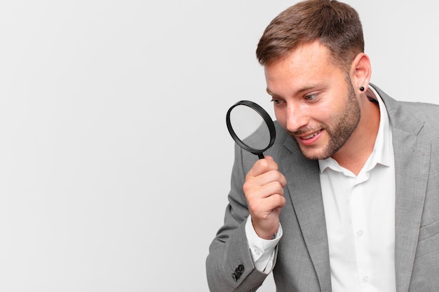 Handsome businessman finfing with a magnifying glass