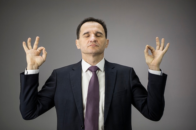 Handsome businessman in formal clothes relaxing and meditation