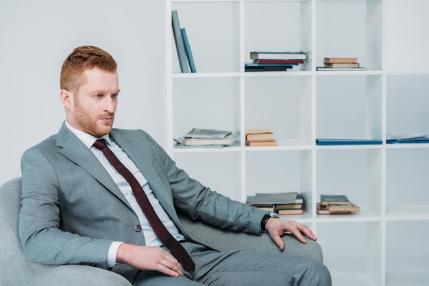 Handsome businessman in grey suit sitting in office