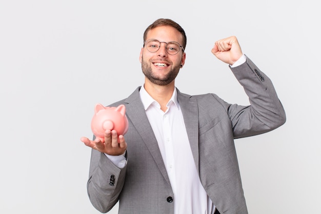 Handsome businessman holding a piggy bank. savings concept