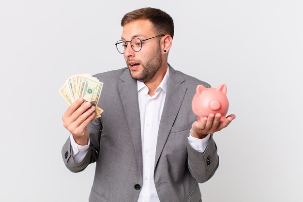 Handsome businessman holding a piggy bank. savings concept