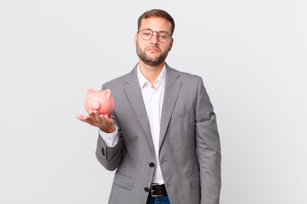 Handsome businessman holding a piggy bank. savings concept