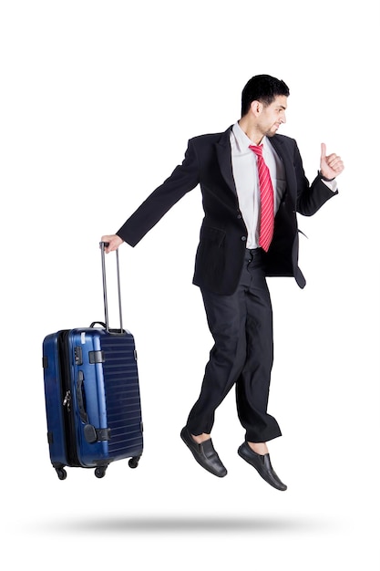 Handsome businessman jumping with his suitcase