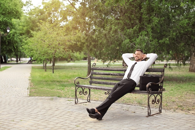 Foto uomo d'affari bello che si rilassa nel parco?