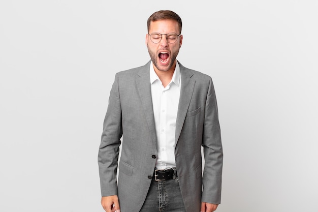 Handsome businessman shouting aggressively, looking very angry