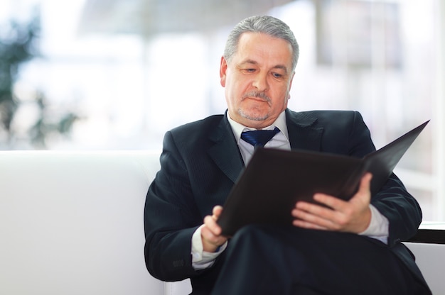 Handsome businessman sitting on the sofa in the office