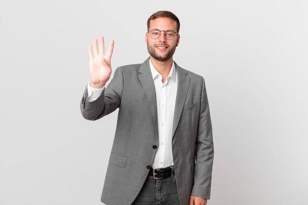 Handsome businessman smiling and looking friendly, showing number four